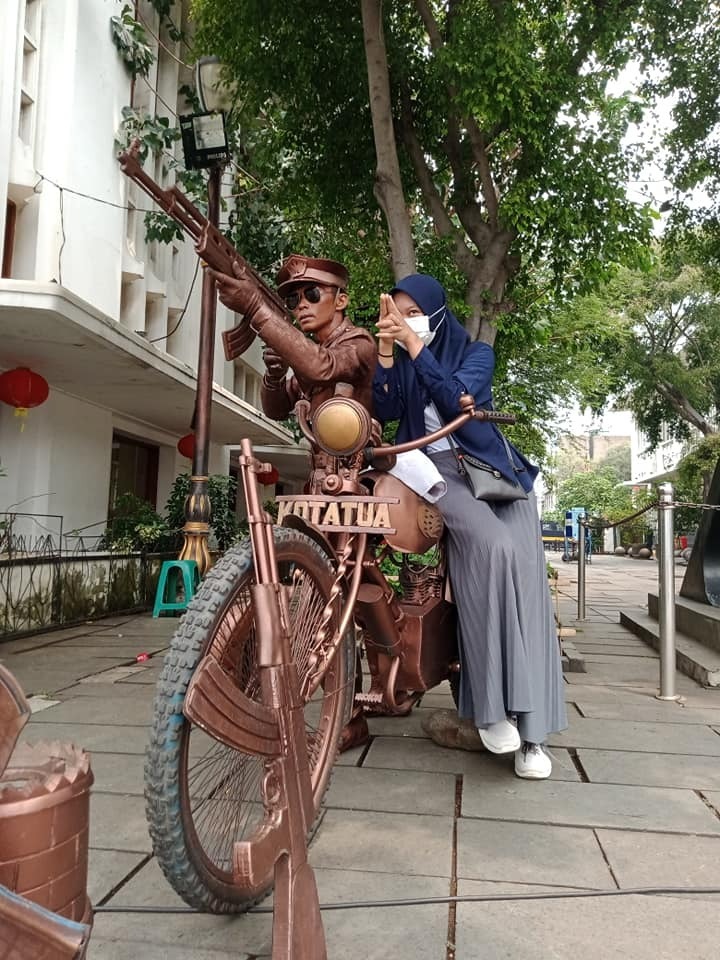 Milaa posing on statue in Kotatua